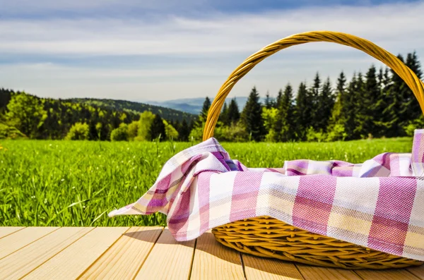 Cesta de piquenique na mesa de madeira — Fotografia de Stock