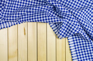 Ahşap masa üzerinde mavi katlanmış masa örtüsü