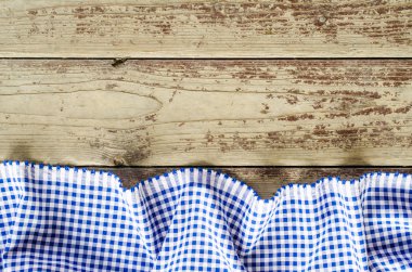 Ahşap masa üzerinde mavi katlanmış masa örtüsü