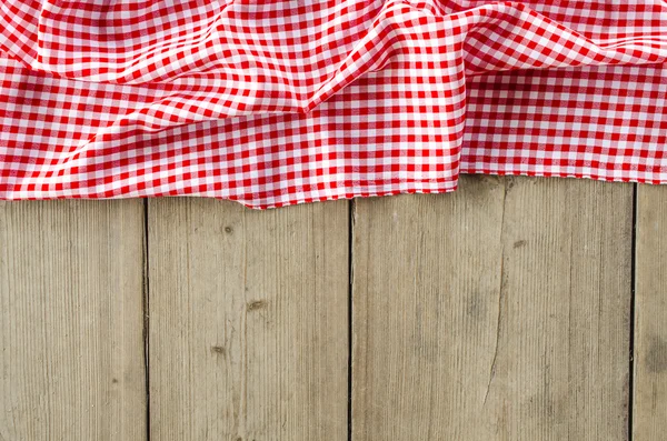 Red folded tablecloth over wooden table — Stock Photo, Image