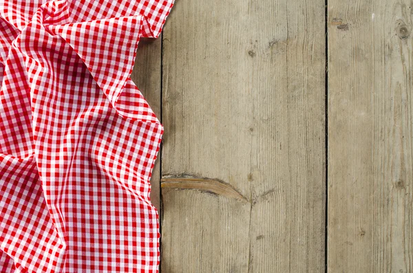 Red folded tablecloth over wooden table — Stock Photo, Image