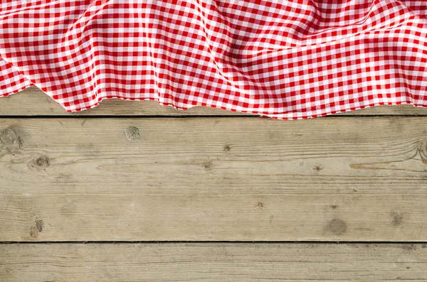 Red folded tablecloth over wooden table — Stock Photo, Image