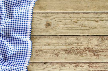 Ahşap masa üzerinde mavi katlanmış masa örtüsü