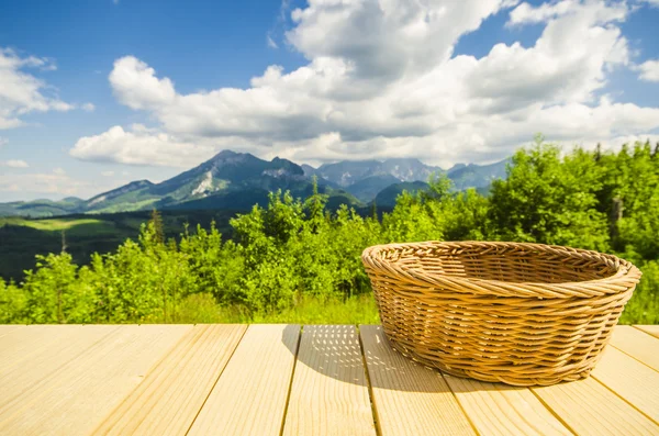 Порожній стіл і плетений кошик з пейзажним фоном — стокове фото