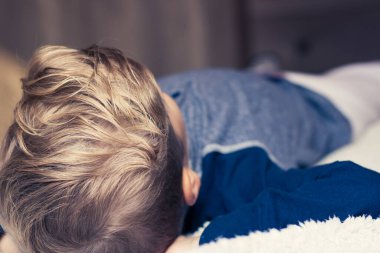 Çocuğun yatağa uzanıp kestirirken yakın plan fotoğrafı.. 