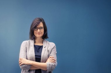 Tatmin olmuş bir iş kadını ve kadın lider. Kameraya bakarak kollarını kavuşturan kendine güvenen kadın girişimcinin portresi. Boşluğu kopyala