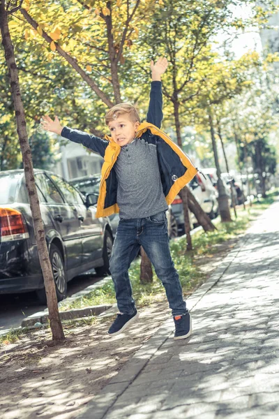 路上で石鹸の泡をキャッチしようとしてジャンプしながら楽しい子供がいる — ストック写真