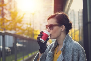 Şehirdeki tek kullanımlık bardaktan kahve içen güzel bir kadın. Kahve hazır..