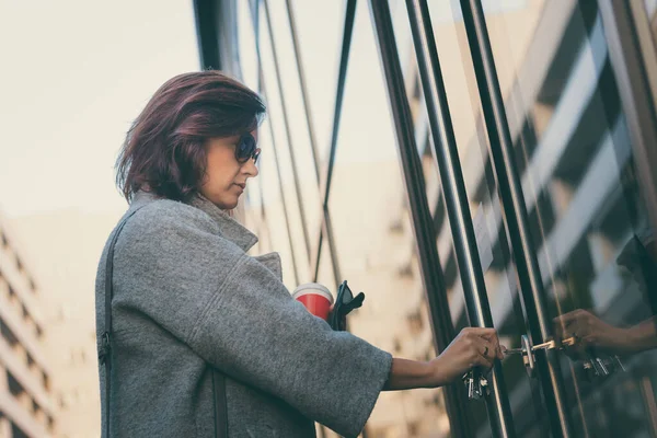 Güzel bir kadın anahtarla kapıyı açıyor ve apartmana giriyor.. 