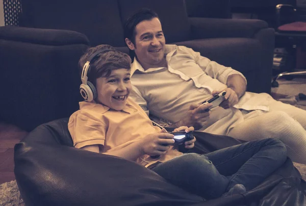 Безтурботний Хлопчик Його Батько Розважаються Граючи Відеоігри Разом Вдома — стокове фото