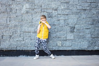 Mutlu çocuk duvarın karşısında dans ederken eğleniyor. Boşluğu kopyala. 