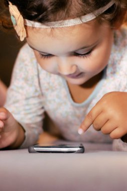 Evde akıllı telefon kullanan sevimli küçük kız. Boşluğu kopyala.