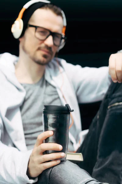 헤드폰을 야외에서 선크림이든 커피를 마시고 남자가 가까이서 — 스톡 사진