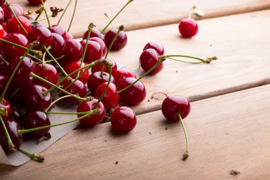 Tahta bir masada olgun kirazlar