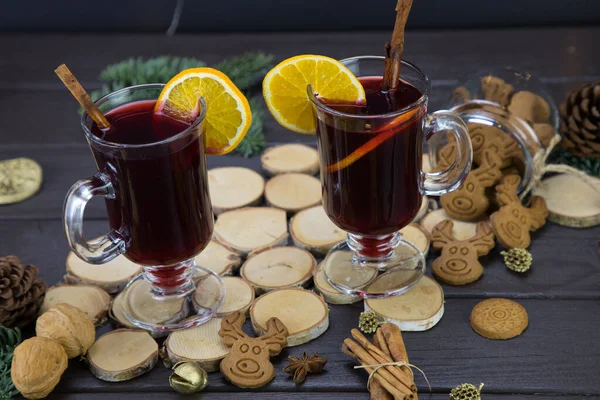 Кружки теплого вина с апельсином, печеньем и корицей, сушеные фрукты и ели, традиционный горячий напиток на Рождество, крупным планом теплое вино — стоковое фото