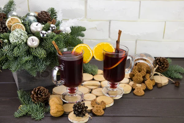 Mugs of warm wine with orange, cookies and cinnamon, dried fruit and spruce branches, hot drink for Christmas, — Stock Photo, Image
