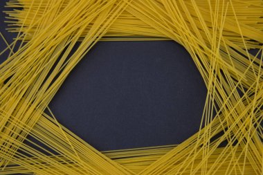 Siyah panoramik çekimde izole edilmiş çiğ İtalyan spagettisinin üst görüntüsü.