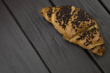 Tahta zemin üzerinde çikolata olan lezzetli kruvasanlar.