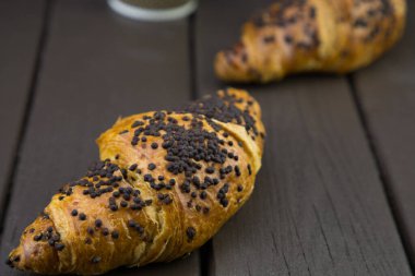 Tahta zemin üzerinde çikolata olan lezzetli kruvasanlar.