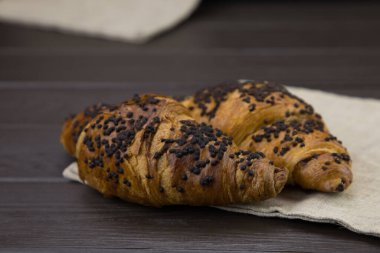 Tahta zemin üzerinde çikolata olan lezzetli kruvasanlar.