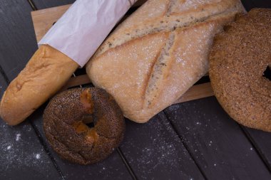 Fırın - siyah tahtada ekmek ve çörekler üzerinde altın kırsal ekmek ve üst görünüm