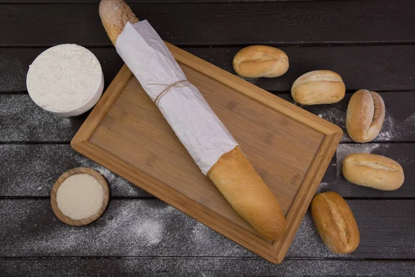 Padaria - ouro rústico crosta pães de pão e pães sobre fundo de quadro preto vista superior — Fotografia de Stock