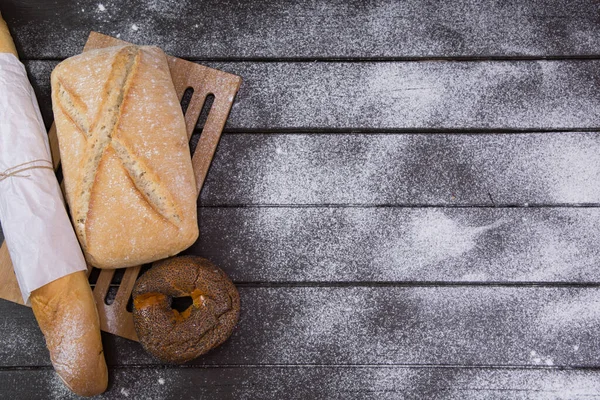 Padaria - ouro rústico crosta pães de pão e pães sobre fundo de quadro preto vista superior — Fotografia de Stock