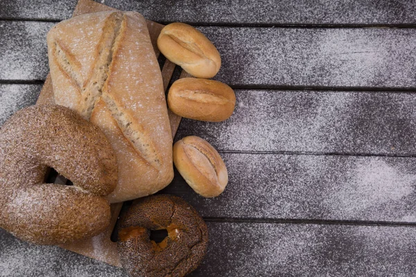 Padaria - ouro rústico crosta pães de pão e pães sobre fundo de quadro preto vista superior — Fotografia de Stock