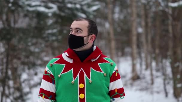 Retrato Joven Suéter Navidad Con Una Máscara Mira Alrededor Medio — Vídeos de Stock