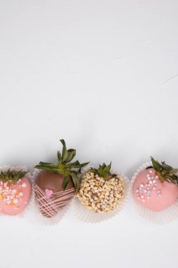 Çeşit çeşit çikolatalı çilek, tatlı tatlı, farklı çikolatalarda böğürtlen ve fındık serpiştirilmiş..