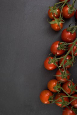 Sağlıklı vejetaryen yemeği, kiraz domatesi, taş tabakta boş yer..