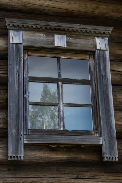 Wooden windows in old houses in the Russian north. Beautiful frames. Woodcarving. Traditional housing construction wood. — Stock Photo, Image