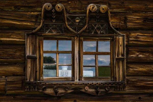 Houten ramen in oude huizen in het Russische Noorden. Mooie frames. Houtsnijden. Traditioneel huisvesting constructie hout. — Stockfoto