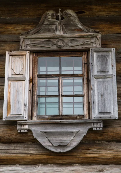 Houten ramen in oude huizen in het Russische Noorden. Mooie frames. Houtsnijden. Traditioneel huisvesting constructie hout. — Stockfoto