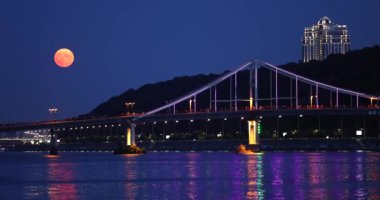 Full Moon is rising over the Pedestrian Bridge with at night in Kyiv city, Ukraine