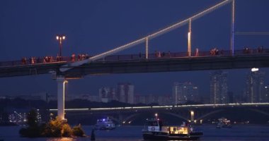 The boats under the Pedestrian Bridge with at night in Kyiv city, Ukraine