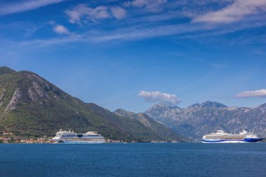 Kotor, Karadağ - 17 Eylül 2025: AIDAblu ve Marella Explorer 2 adlı iki yolcu gemisi açık mavi bir gökyüzü altında Karadağ 'ın Kotor Körfezi manzarasına demirledi.