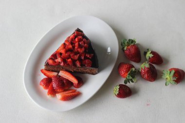 Çikolatalı kek dilimi, çikolatalı ganache ve üstüne de sevgililer günü randevusu için taze çilek ve Noel ziyafeti.