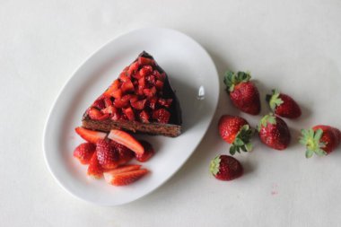 Çikolatalı kek dilimi, çikolatalı ganache ve üstüne de sevgililer günü randevusu için taze çilek ve Noel ziyafeti.