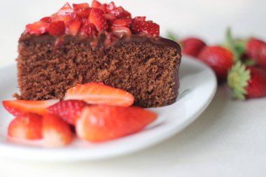 Çikolatalı kek dilimi, çikolatalı ganache ve üstüne de sevgililer günü randevusu için taze çilek ve Noel ziyafeti.