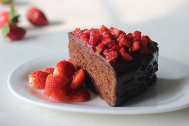 Çikolatalı kek dilimi, çikolatalı ganache ve üstüne de sevgililer günü randevusu için taze çilek ve Noel ziyafeti.