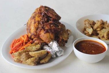 Noel, Paskalya ve diğer festivaller için hazırlanmış patates dilimleri ve sotelenmiş havuçlarla tam tavuk rostosu.