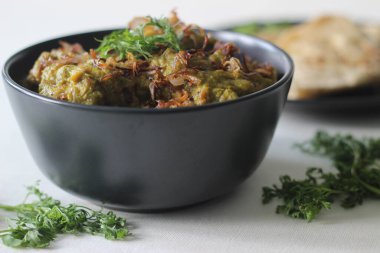 Ev yapımı baharatlı kişniş tavuğu öğle veya akşam yemeğinde Hint ekmeği ile servis edilir.