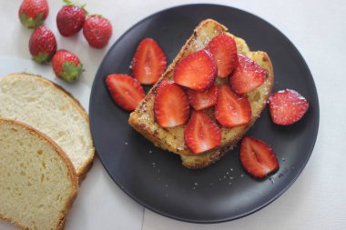 Kahvaltıda taze çilekli yumurtalı ekmek. Beyaz arkaplanda çekilen.