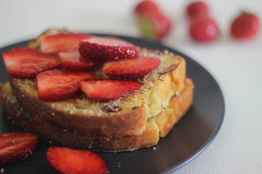 Kahvaltıda taze çilekli yumurtalı ekmek. Beyaz arkaplanda çekilen.