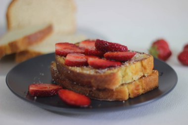 Kahvaltıda taze çilekli yumurtalı ekmek. Beyaz arkaplanda çekilen.