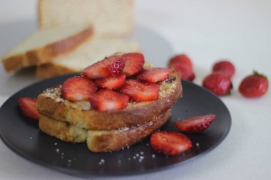 Kahvaltıda taze çilekli yumurtalı ekmek. Beyaz arkaplanda çekilen.