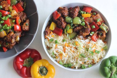 Hint baharatlı sebzeli havuç ve kızarmış pilav, yanında da soğuk tavuk. Beyaz arka planda ev yapımı yemek çekimi.