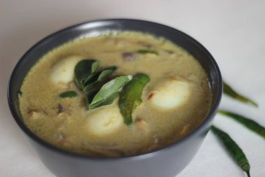 Kerala stili Hint cevizi sütlü yumurta körisi, namı diğer Nadan Mutta Curry. Beyaz arka planda ev yapımı yemek çekimi