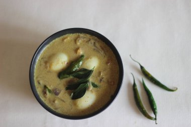 Kerala stili Hint cevizi sütlü yumurta körisi, namı diğer Nadan Mutta Curry. Beyaz arka planda ev yapımı yemek çekimi